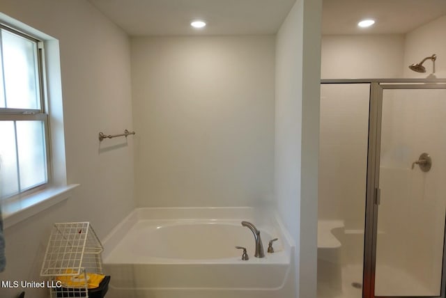 bathroom with recessed lighting, a garden tub, and a shower stall