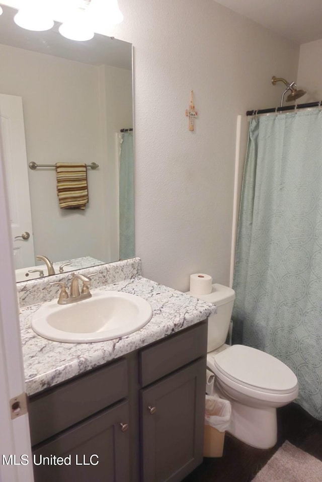 bathroom featuring toilet, a shower with curtain, and vanity