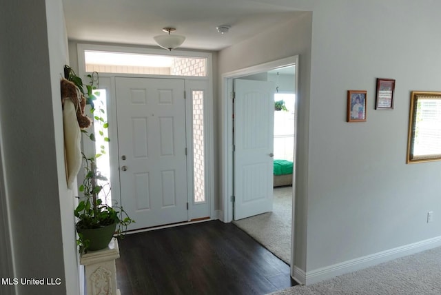 foyer featuring baseboards and wood finished floors