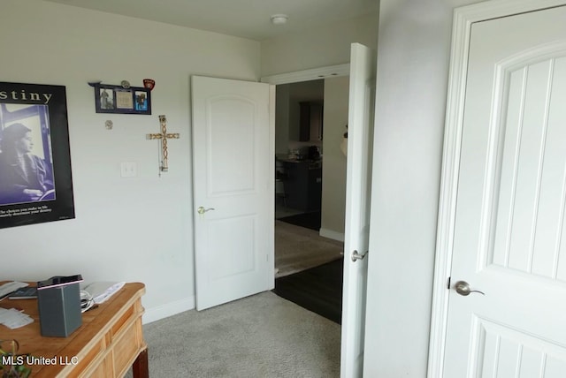 hall with carpet floors and baseboards