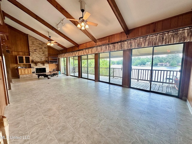 577 W Lakeshore Dr, Carriere, MS 39426 - living room with ceiling fan, wood walls, beam ceiling, high vaulted ceiling, and a brick fireplace