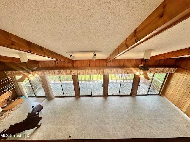 577 W Lakeshore Dr, Carriere, MS 39426 - unfurnished living room featuring ceiling fan, wood walls, rail lighting, and a textured ceiling
