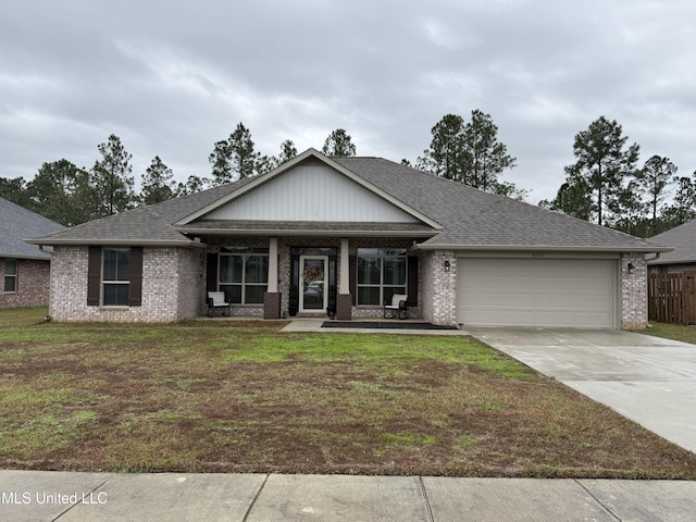 view of front of house featuring covered porch, a garage, and a front lawn