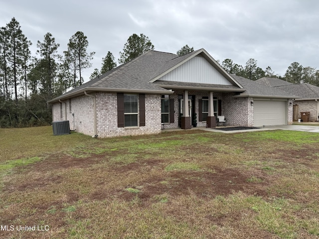 view of front of house with a front yard, a garage, and central AC unit