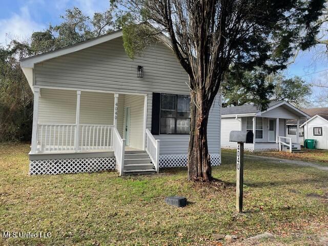 view of front facade featuring covered porch and a front lawn