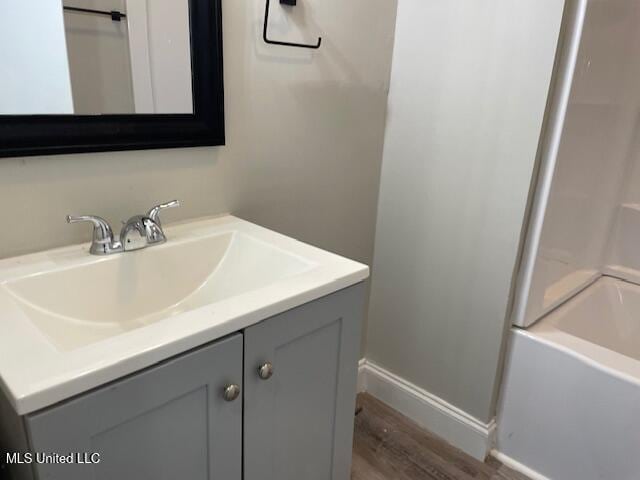 bathroom with shower / bath combination, wood-type flooring, and vanity