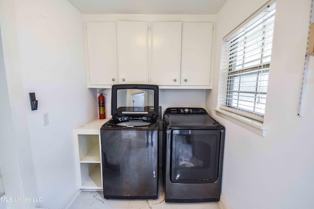 washroom with washing machine and dryer and cabinets