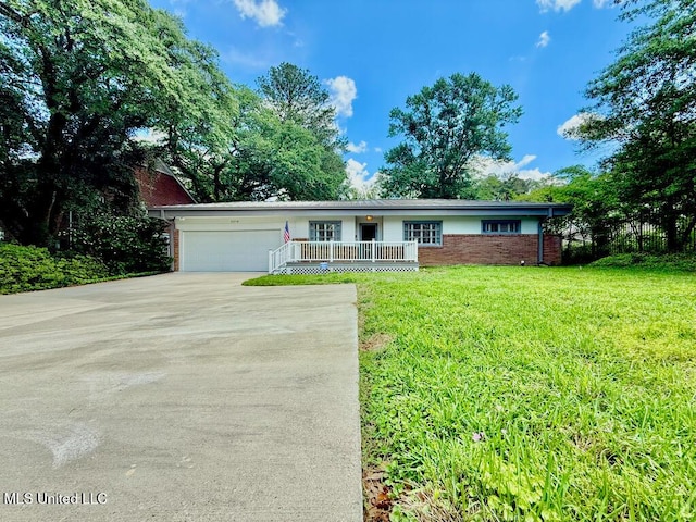 ranch-style home with an attached garage, brick siding, a front yard, covered porch, and driveway