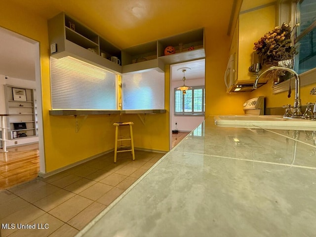 interior space with a sink, baseboards, and tile patterned flooring