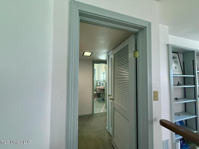 hall featuring carpet flooring