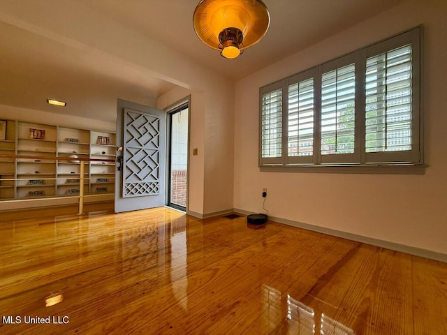 spare room featuring baseboards and wood finished floors