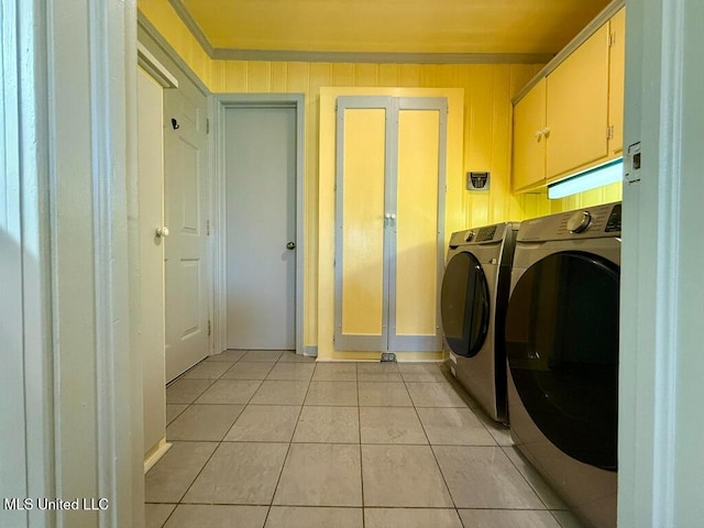 clothes washing area featuring light tile patterned flooring, cabinet space, and washing machine and clothes dryer
