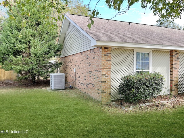 view of side of home with a yard and cooling unit