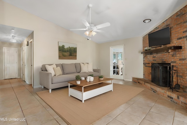 tiled living room with ceiling fan, lofted ceiling, and a fireplace