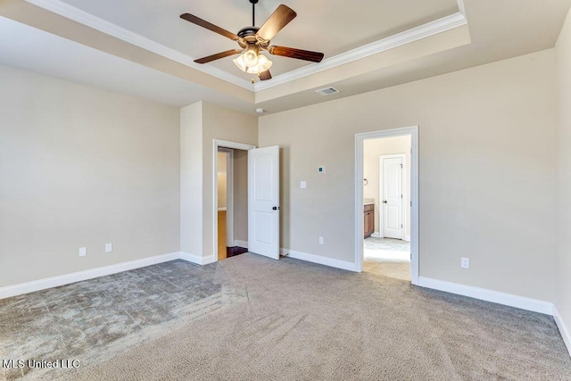 unfurnished bedroom with ceiling fan, carpet, connected bathroom, and a tray ceiling