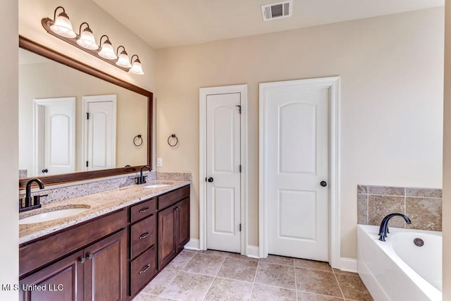 bathroom with a tub, tile patterned floors, and vanity