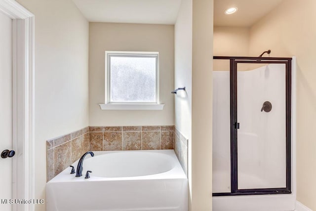 bathroom featuring shower with separate bathtub