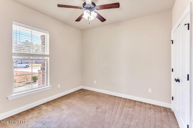 spare room with ceiling fan, plenty of natural light, and carpet