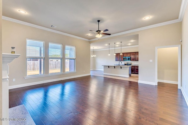 unfurnished living room featuring ceiling fan with notable chandelier, sink, and crown molding