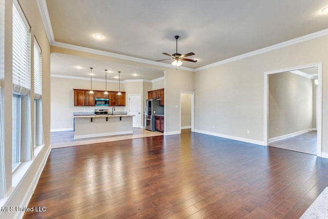 unfurnished living room featuring ceiling fan, dark hardwood / wood-style floors, sink, and crown molding