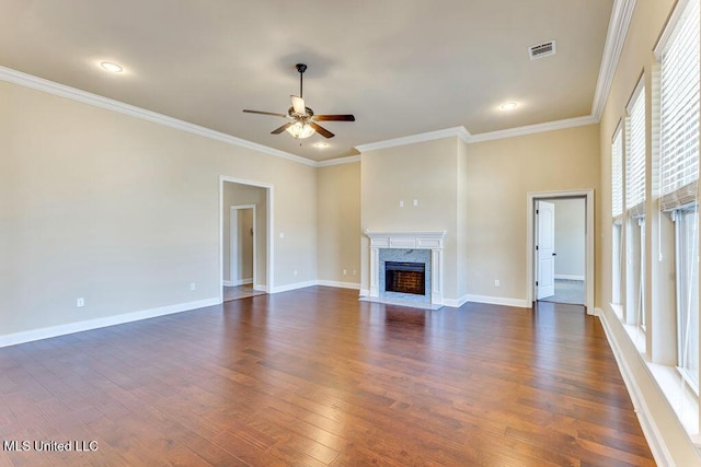 unfurnished living room with dark wood-type flooring, ceiling fan, ornamental molding, and a fireplace