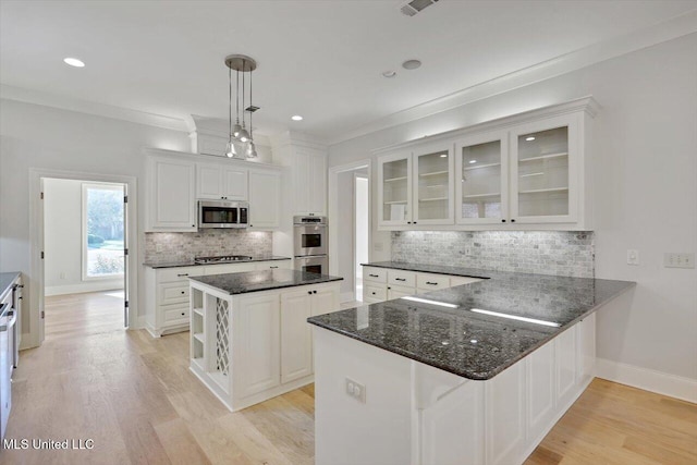 kitchen featuring hanging light fixtures, kitchen peninsula, a center island, white cabinetry, and appliances with stainless steel finishes