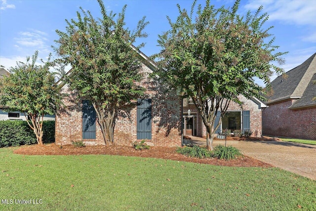 view of property hidden behind natural elements featuring a front lawn