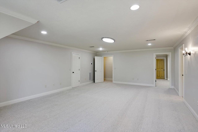 spare room with ornamental molding and light colored carpet