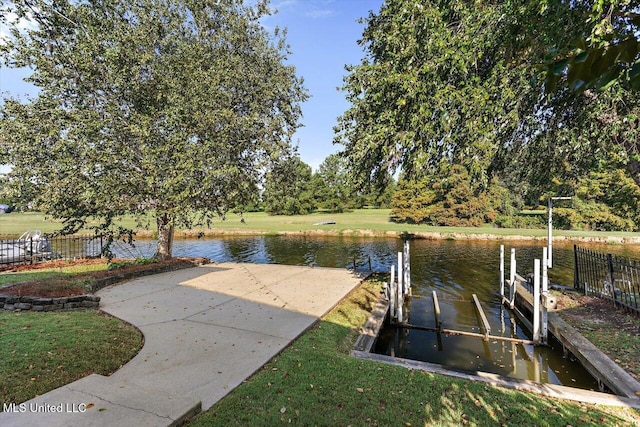 dock area featuring a lawn and a water view