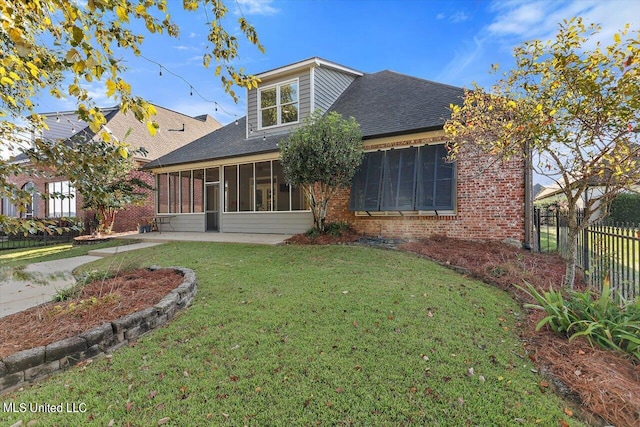 back of house with a sunroom and a lawn