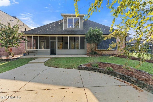 back of property with a yard and a sunroom