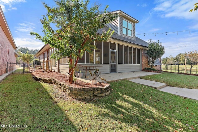 back of house featuring a patio, a lawn, and a sunroom