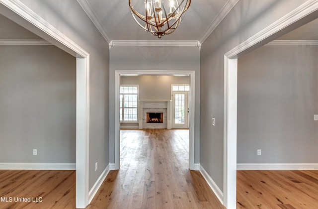 hallway featuring hardwood / wood-style floors, crown molding, and baseboards