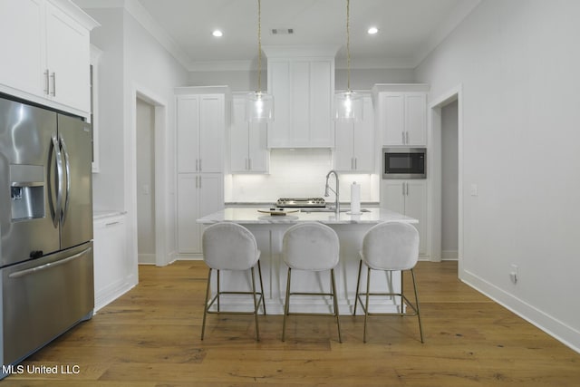 168 Shore View Dr, Madison, MS 39110 - kitchen with appliances with stainless steel finishes, crown molding, backsplash, a breakfast bar, and white cabinetry