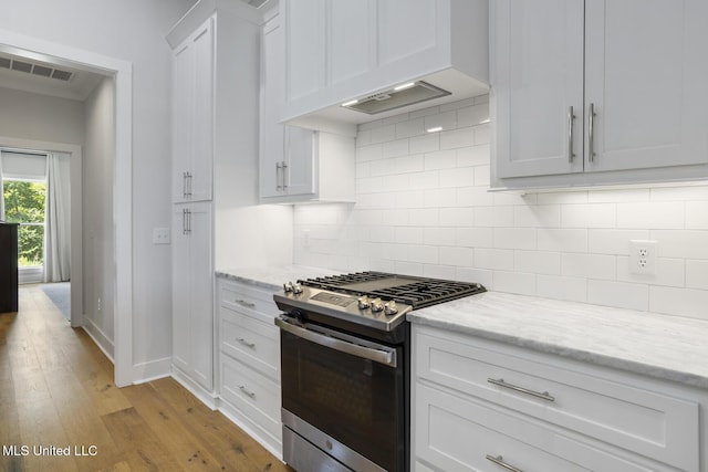 168 Shore View Dr, Madison, MS 39110 - kitchen featuring gas stove, premium range hood, light wood-style floors, white cabinets, and decorative backsplash