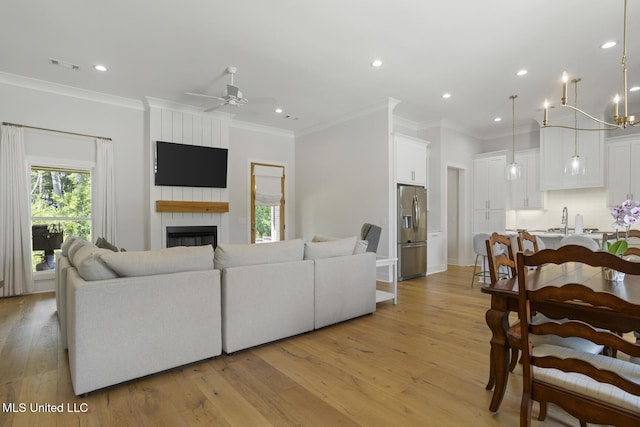 168 Shore View Dr, Madison, MS 39110 - living room with crown molding, light wood-style flooring, recessed lighting, ceiling fan, and a fireplace