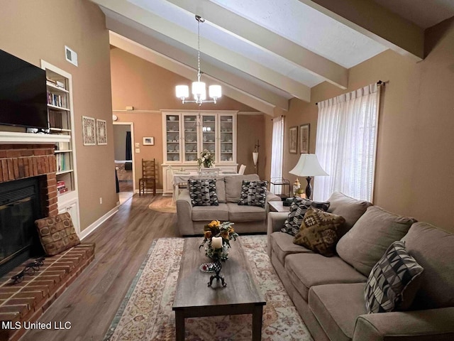 living area featuring a brick fireplace, wood finished floors, baseboards, beamed ceiling, and an inviting chandelier