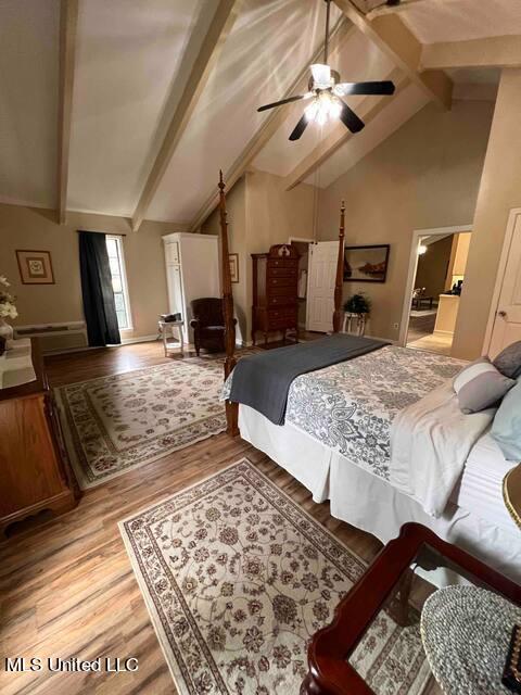 bedroom with high vaulted ceiling, beam ceiling, and wood finished floors