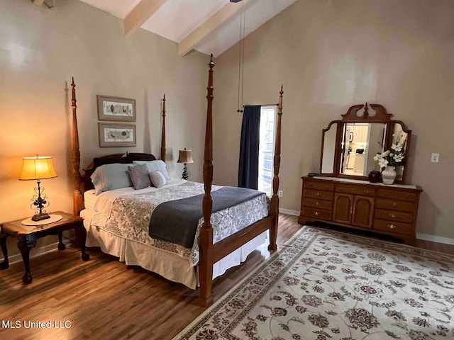 bedroom with high vaulted ceiling, beamed ceiling, and hardwood / wood-style floors