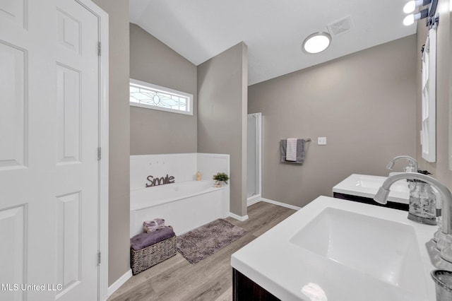 10326 Amanda Dr, Olive Branch, MS 38654 - full bath featuring double vanity, wood finished floors, a bath, a stall shower, and lofted ceiling
