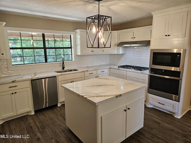 kitchen featuring sink, hanging light fixtures, dark hardwood / wood-style floors, exhaust hood, and appliances with stainless steel finishes