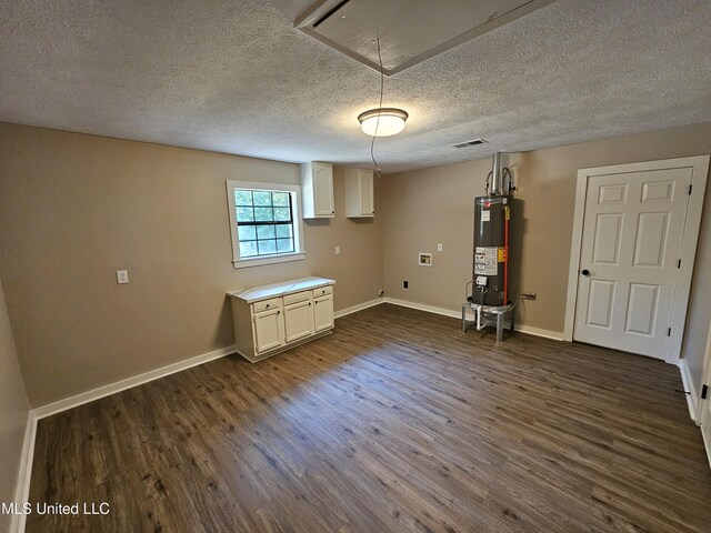 interior space featuring a textured ceiling, gas water heater, and dark wood-type flooring