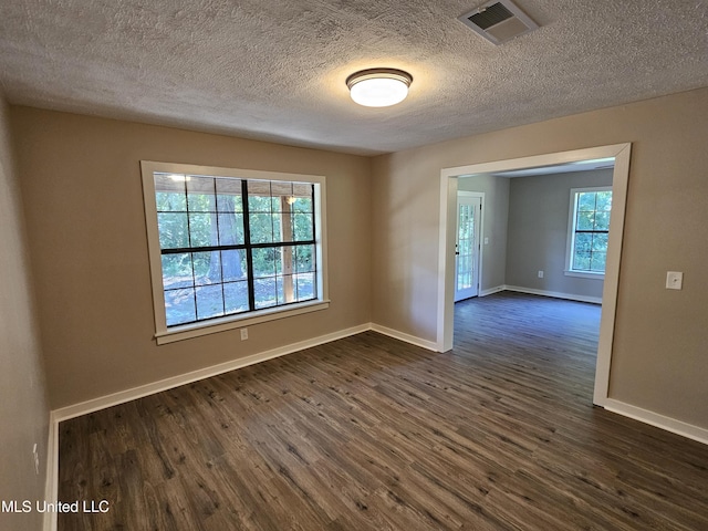 unfurnished room with a textured ceiling and dark wood-type flooring