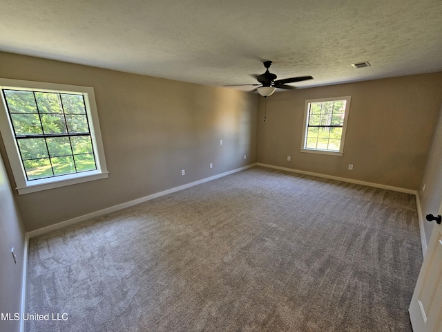 carpeted spare room featuring ceiling fan and a textured ceiling