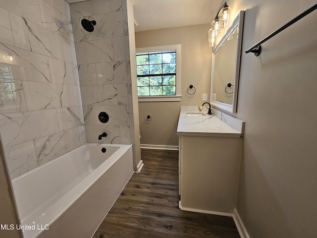 bathroom with vanity, tiled shower / bath, a textured ceiling, and hardwood / wood-style flooring