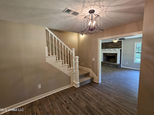 interior space featuring a fireplace, wood-type flooring, and a textured ceiling