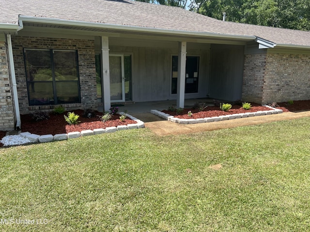 4101 Henderson Rd, Byram, MS 39272 - doorway to property with brick siding, a lawn, a shingled roof, and covered porch