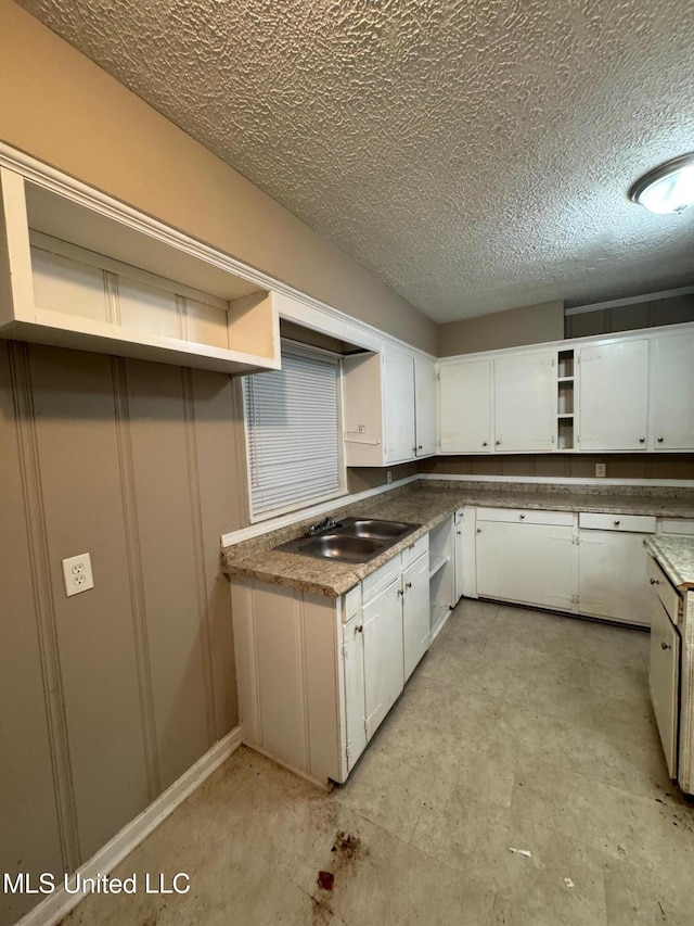 3115 Shirley Dr, Jackson, MS 39212 - kitchen featuring open shelves, a textured ceiling, and white cabinets