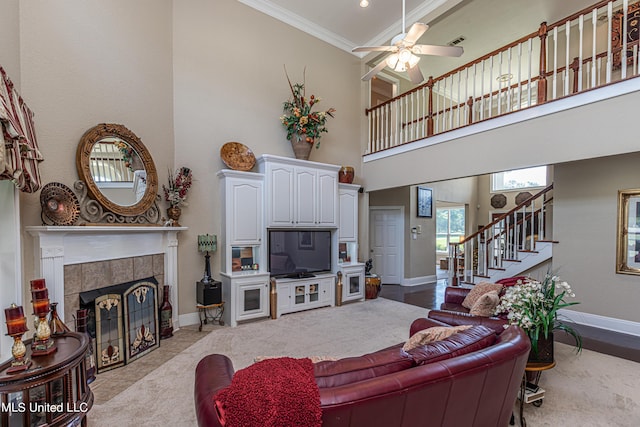 1000 Cedar Hill Rd, Madison, MS 39110 - living room with a towering ceiling, baseboards, crown molding, a tiled fireplace, and ceiling fan