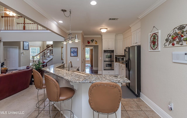 1000 Cedar Hill Rd, Madison, MS 39110 - kitchen featuring stainless steel appliances, a kitchen breakfast bar, light stone countertops, crown molding, and white cabinetry